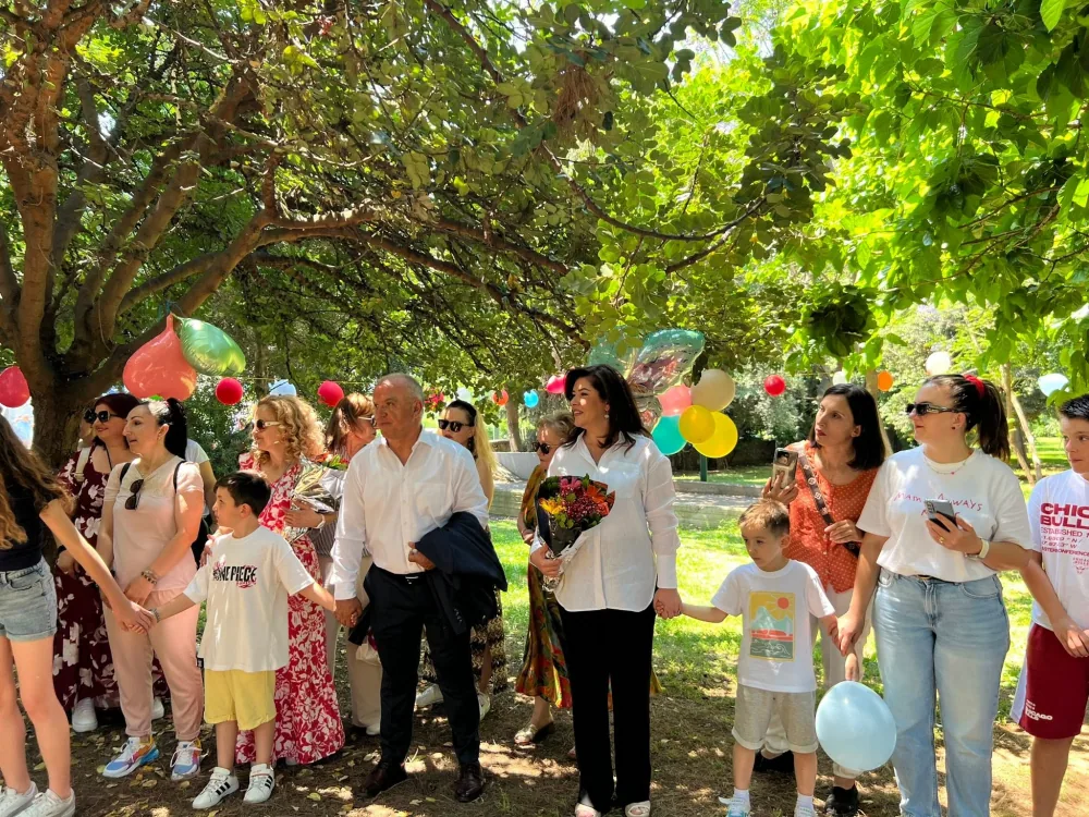 Albanische Kinder, Eltern, Lehrer und Gäste halten sich im Juni 2026 im Rizari Central Park in Athen an den Händen
