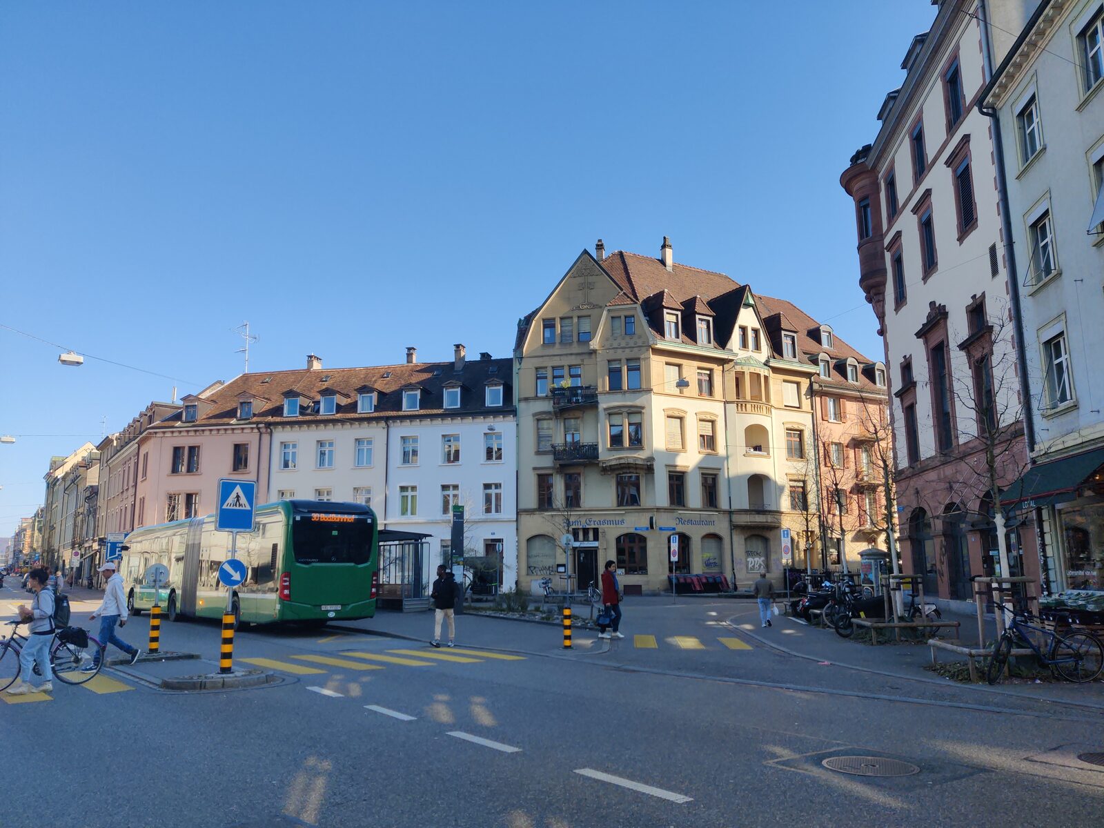 Erasmusplatz in the Matthaeus quarter of Kleinbasel, with a bus, pedestrians crossing and tenement blocks behind