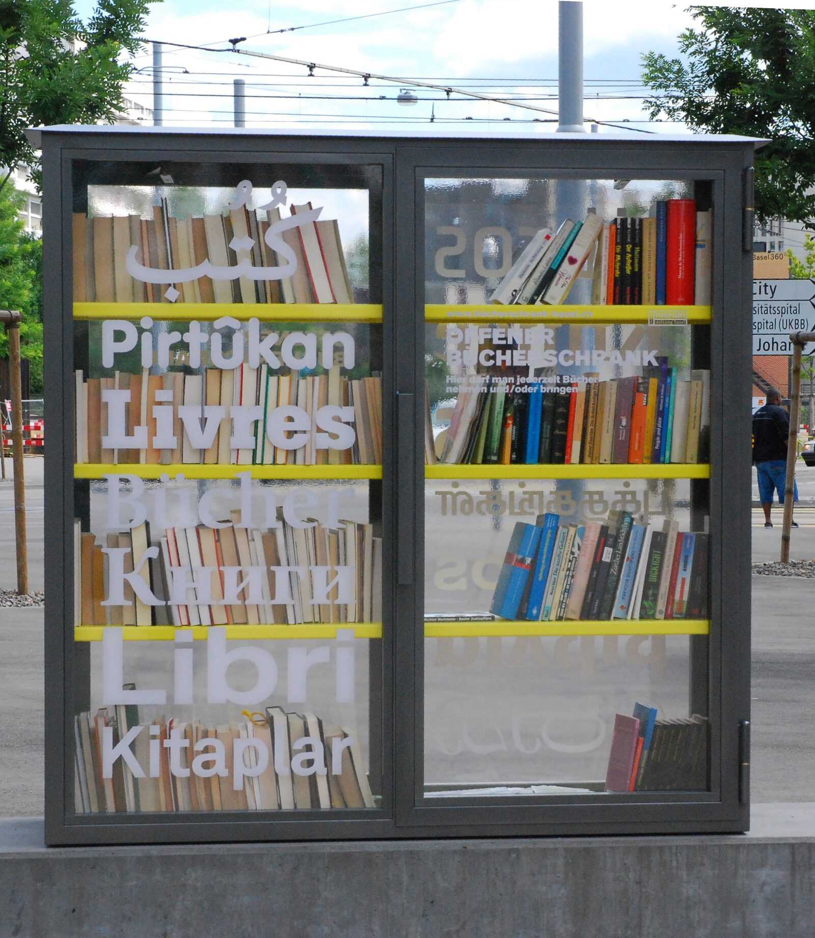A multilingual public bookcase at Voltaplatz in the St. Johann quarter of Basel, labelled in Kurdish, French, German, Turkish and Italian
