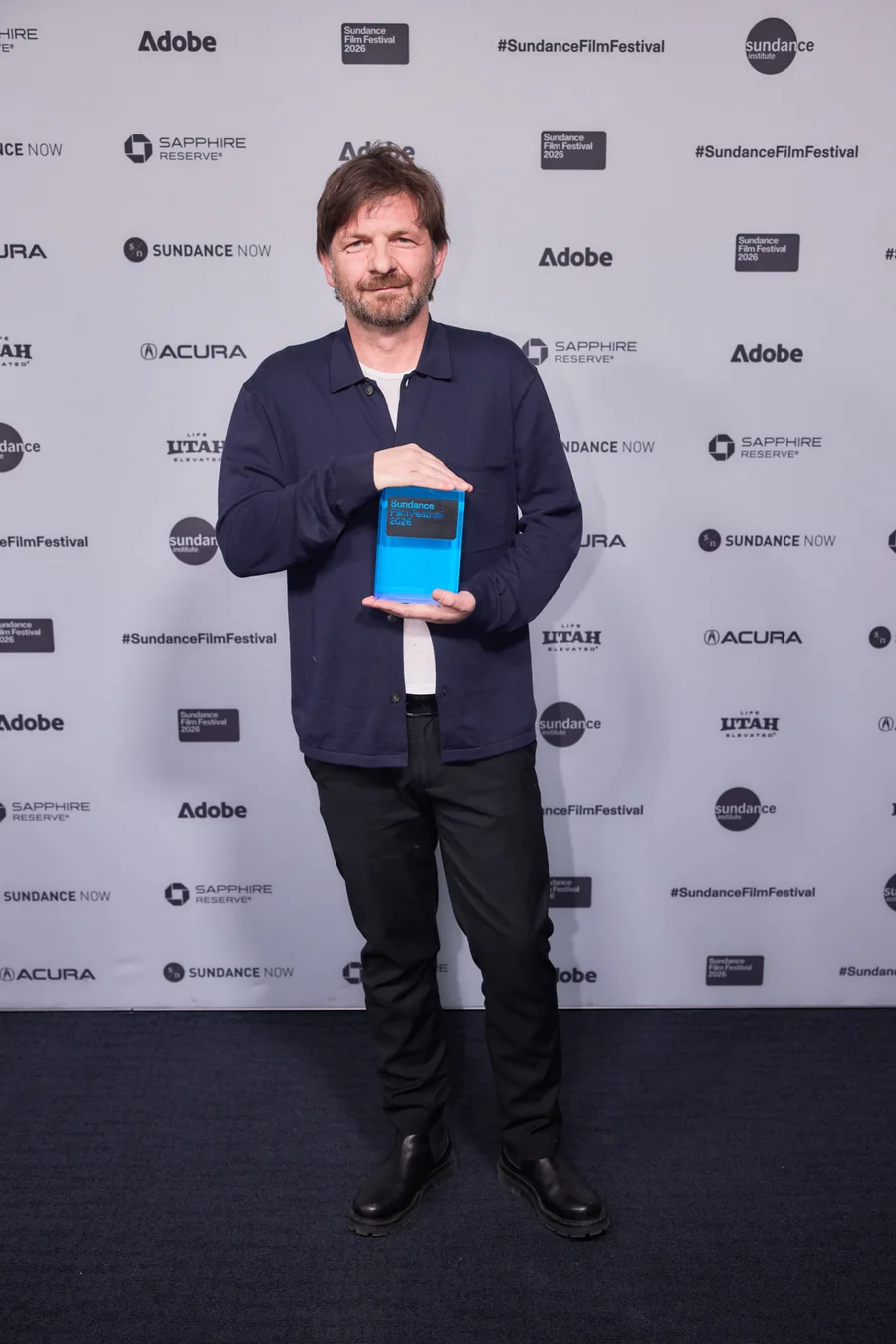 Filmmaker Visar Morina holding his award at the 2026 Sundance Film Festival.