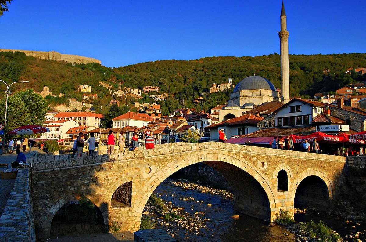 Prizren'deki Osmanlı taş köprüsü; arkasında Sinan Paşa Camii'nin kubbesi ile minaresi, eski şehrin üzerindeki tepede ise kale