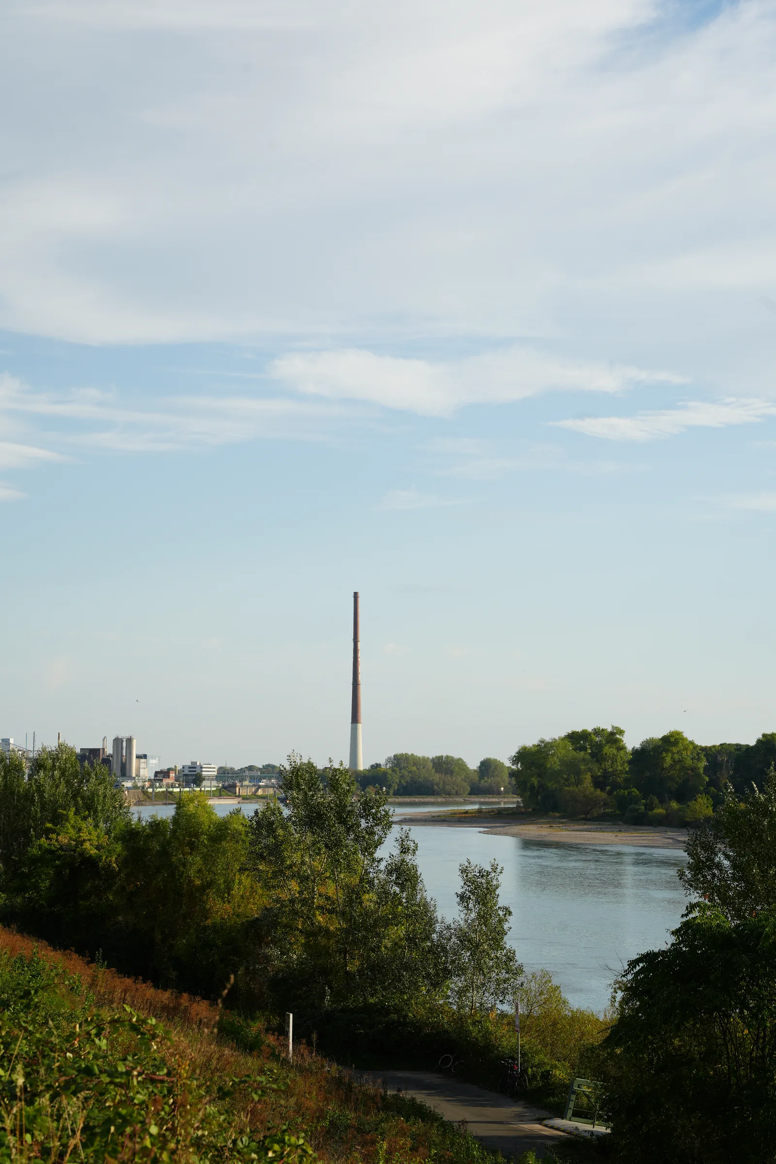 A riverside path, trees and industrial buildings in Leverkusen, photographed for dua.com's city community series