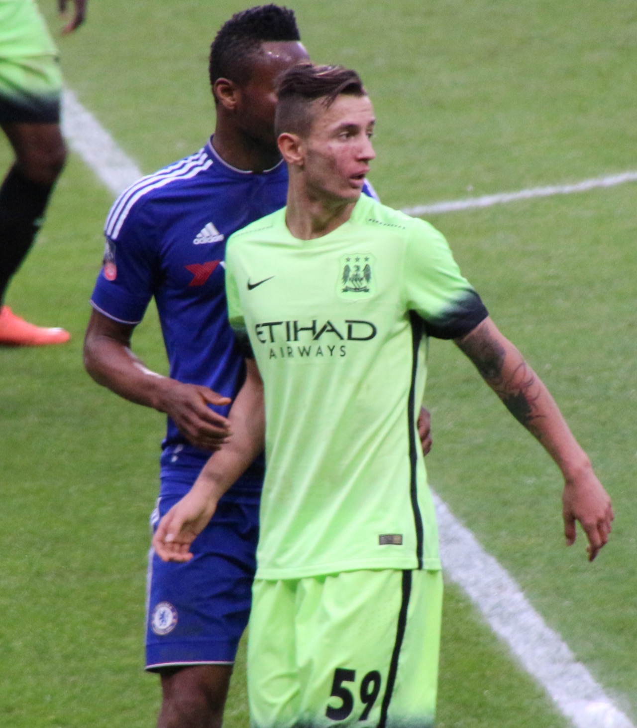 Bersant Celina jugando con el Manchester City con su tercera equipación de color neón