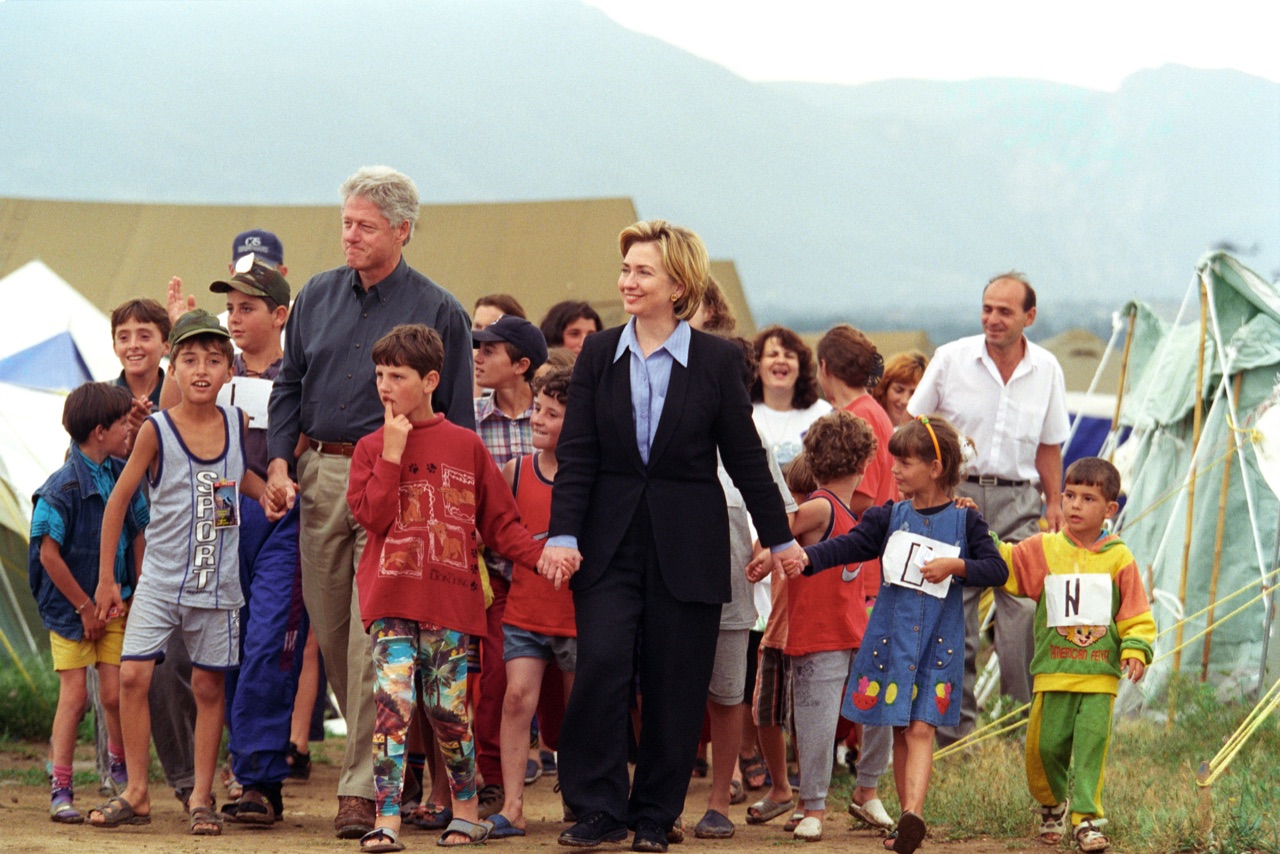 Niños refugiados kosovares agolpados alrededor de unos visitantes en un camino de tierra entre tiendas de campaña, en el campo de refugiados de Stenkovec, cerca de Skopje, en 1999