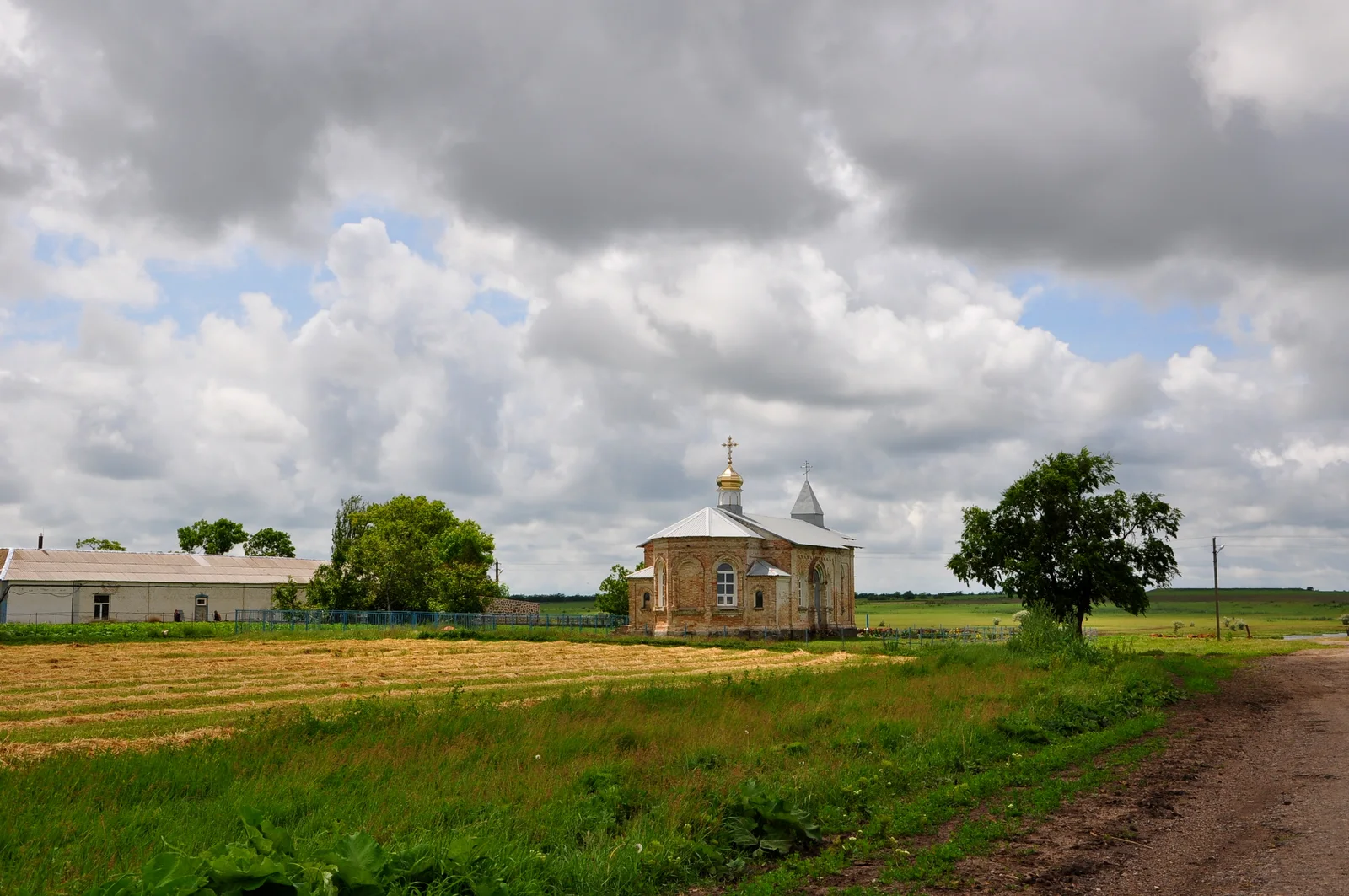 Die Demetrios-Kirche steht allein am Rand eines gemähten Feldes in Hamiwka