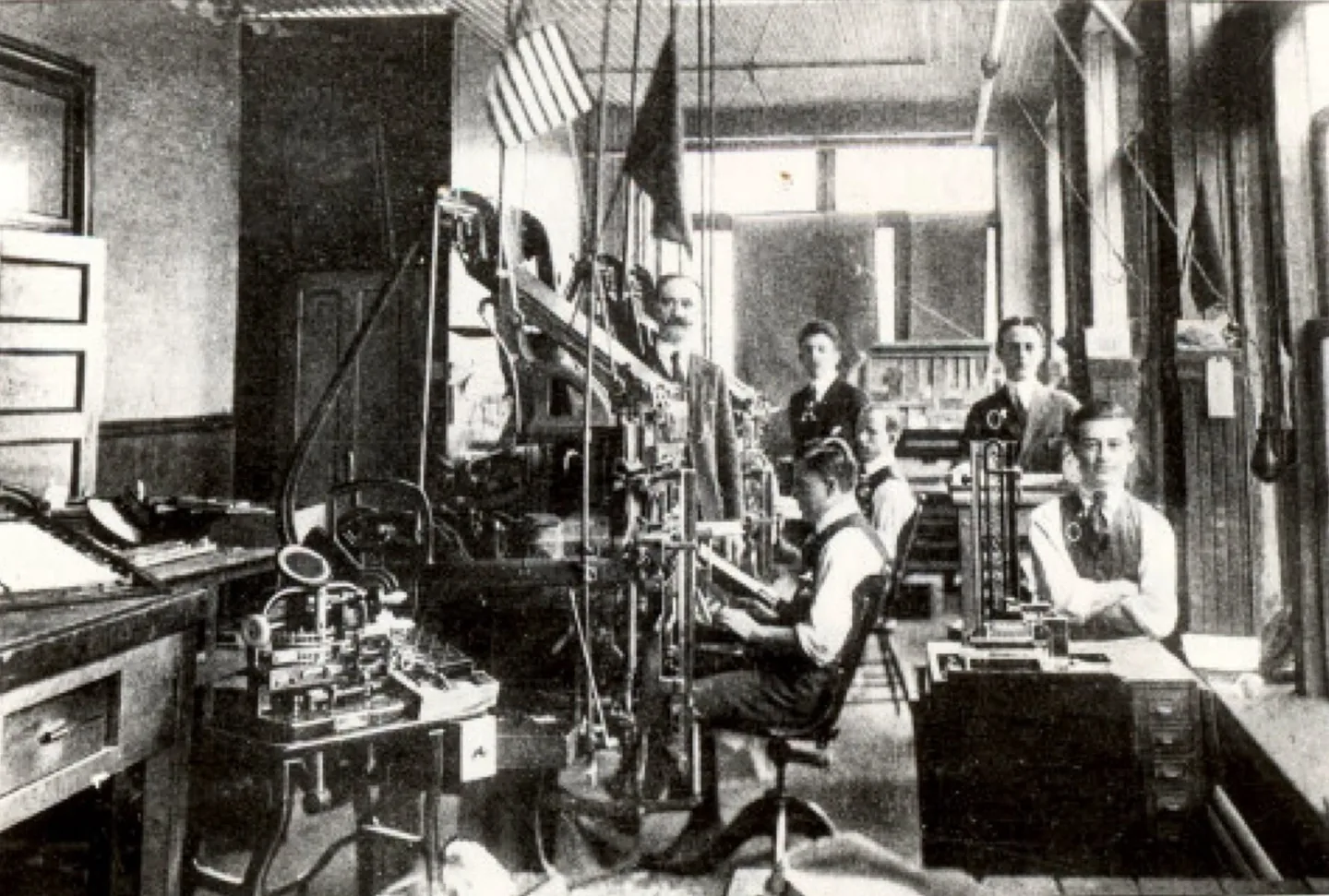 Workers among printing machinery in an archival photograph of the Dielli press