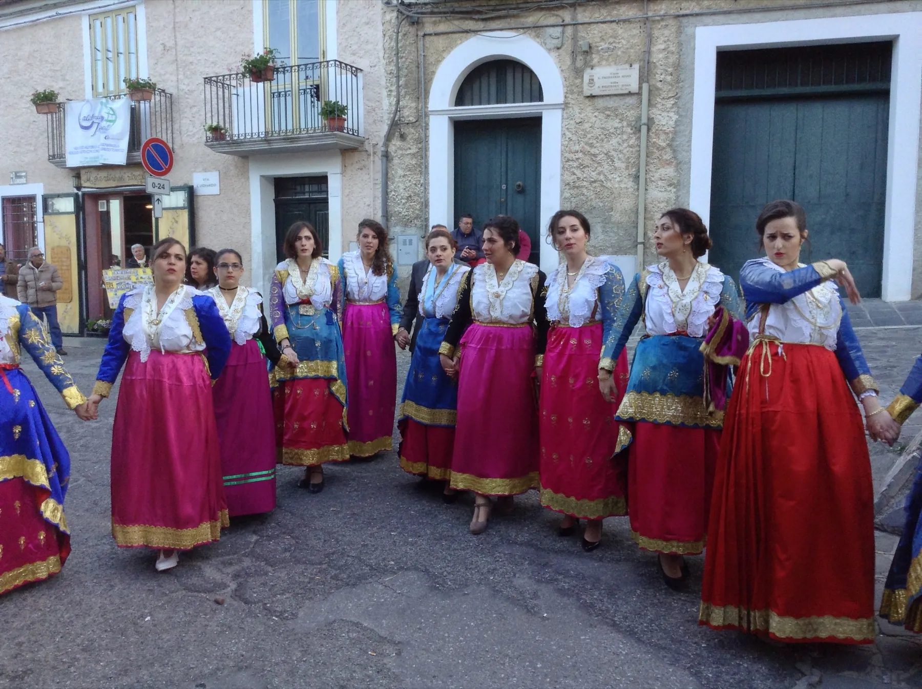 Una cadena de mujeres de distintas edades se da la mano en la plaza de Civita durante las Vallje arbëreshë