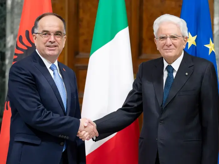 Bajram Begaj y Sergio Mattarella se estrechan la mano ante las banderas albanesa, italiana y de la UE en el Quirinal de Roma en mayo de 2023