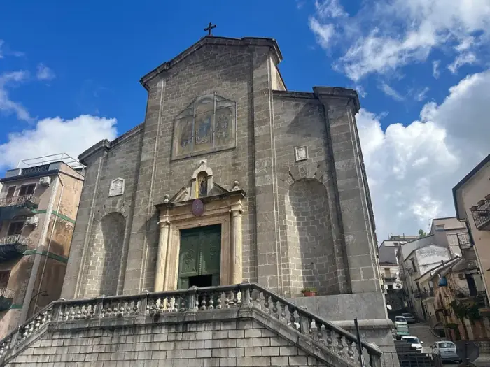 La fachada de piedra gris de la catedral de San Demetrio en Piana degli Albanesi, con su doble escalinata