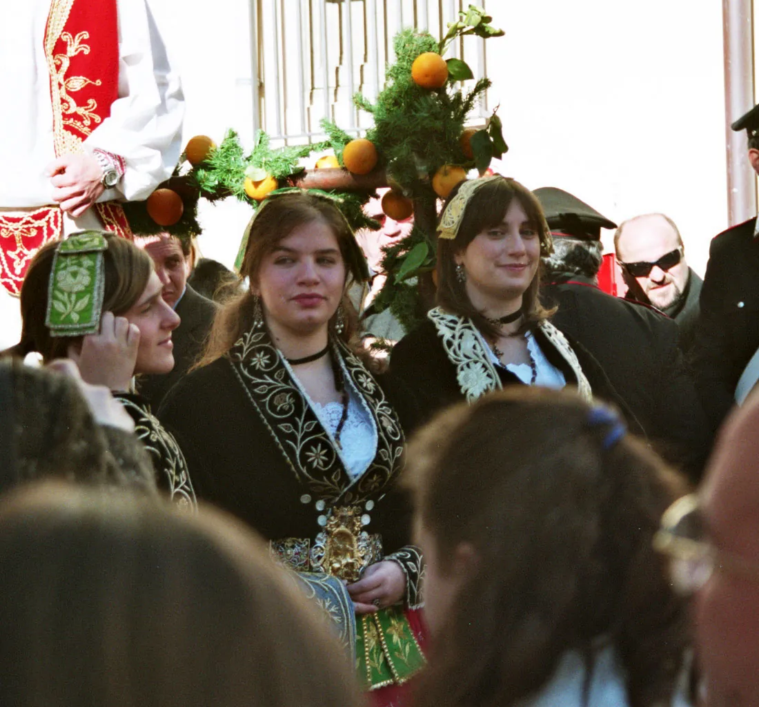 Tres jóvenes con chaquetas de terciopelo negro bordadas en oro durante las celebraciones de la Epifanía en Piana degli Albanesi