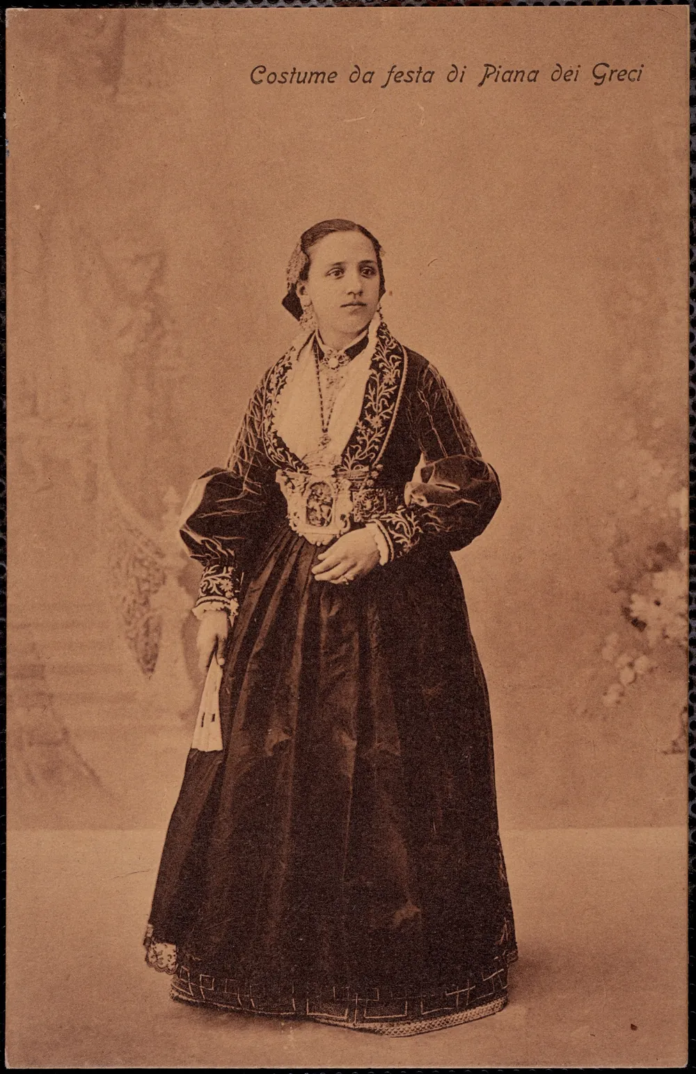 Postal de estudio en sepia de una joven con el traje festivo bordado de Piana dei Greci