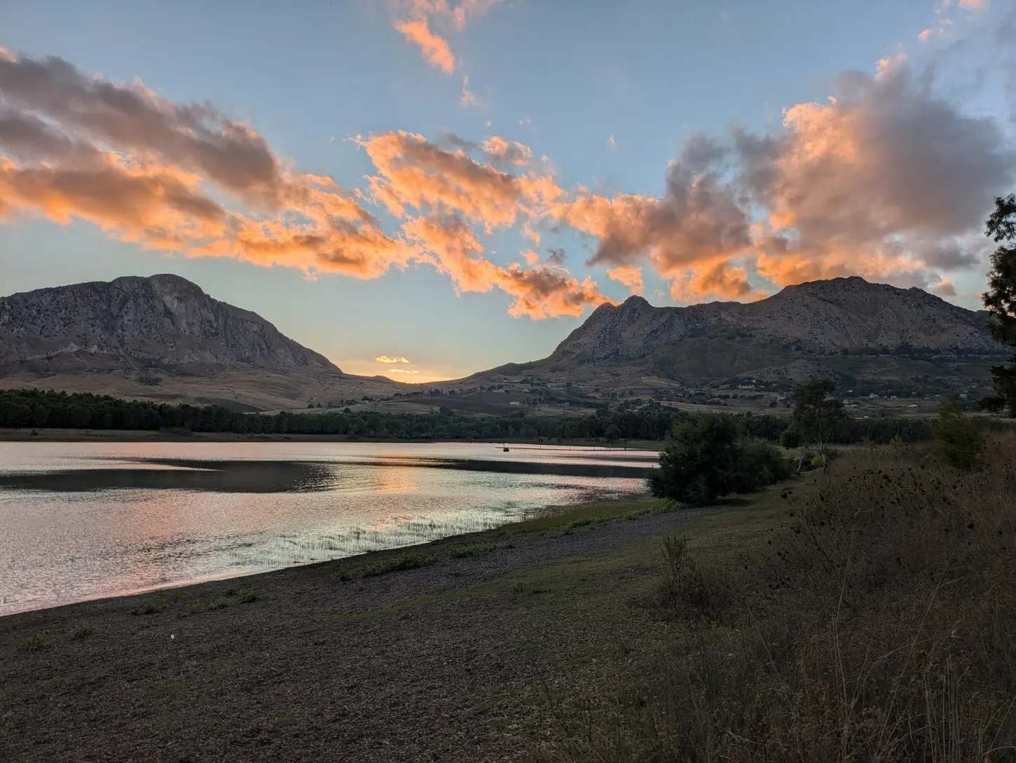 Nubes al atardecer sobre el lago de Piana degli Albanesi entre dos montañas