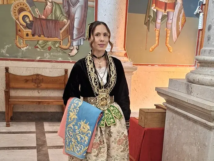 Eine junge Frau in Festtracht in einer Kirche in Piana degli Albanesi am Palmsonntag 2026