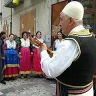 Ein Gitarrist und Sänger in Tracht bei den Vallje in Civita